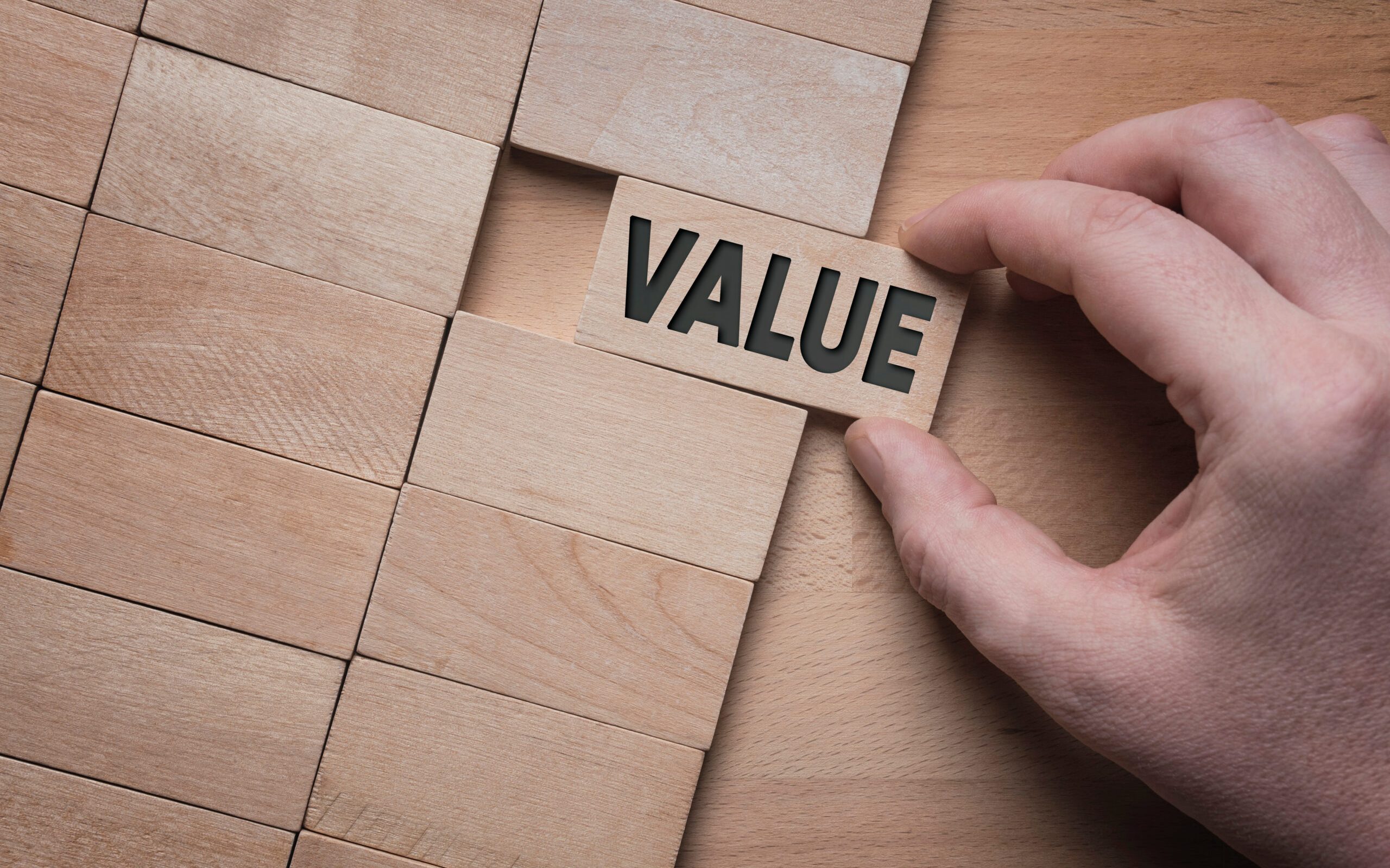 Value word written on wooden block. Add value to your business concept.